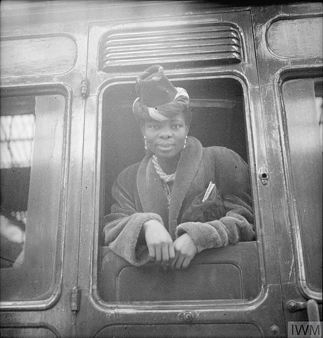 Black and white photograph of Princess Adenrele Ademola posing in the window of a train.
